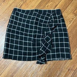 Plaid black and white mini skirt with a ruffle in the front